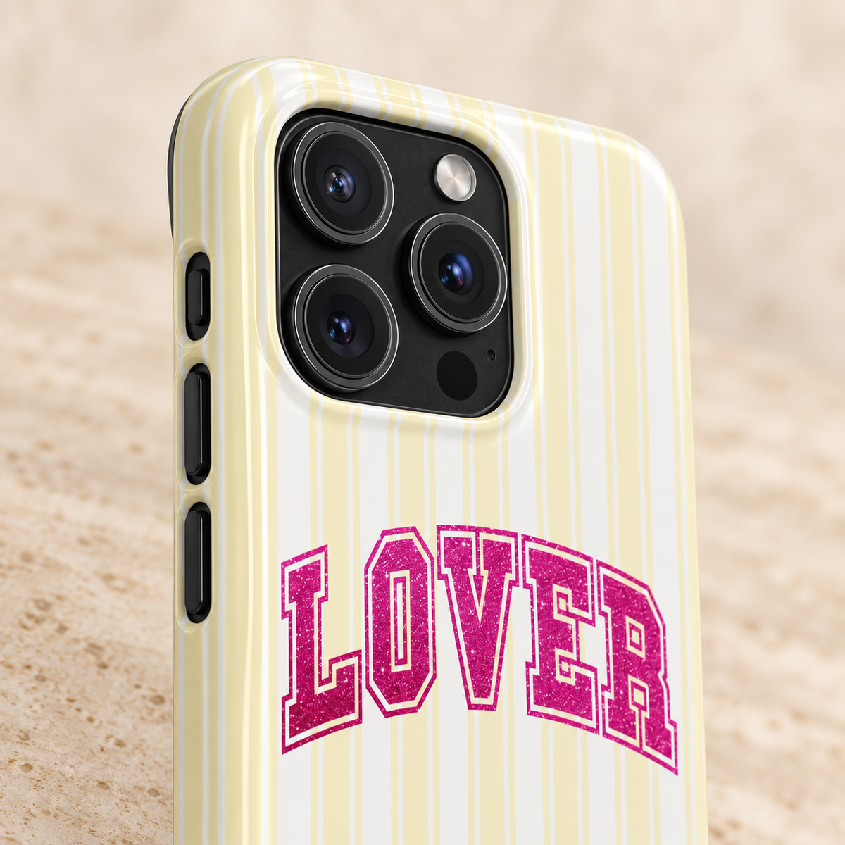 Lover Varsity MagSafe case, pink varsity LOVER lettering on pale yellow stripes, lifestyle close-up of the camera