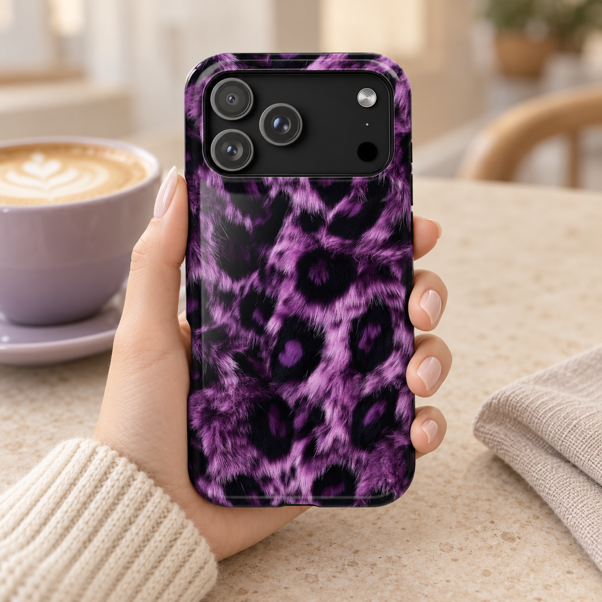 Purple Leopard protective phone case, purple and black leopard spots, lifestyle photo in hand with coffee