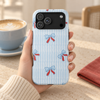 Blue Ribbon Stripe MagSafe case, baby blue bows with red ribbons on wavy blue stripes, lifestyle photo in hand with coffee