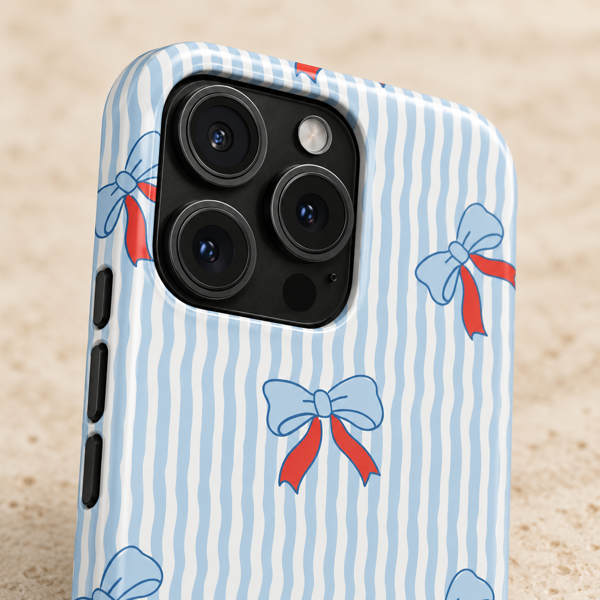 Blue Ribbon Stripe MagSafe case, baby blue bows with red ribbons on wavy blue stripes, lifestyle close-up of the camera