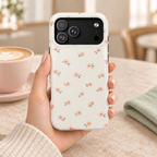 Blush Ditsy Floral MagSafe case, tiny blush blossoms on ivory, lifestyle photo in hand with coffee