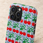 Cherry Bow Stripe MagSafe case, red cherries and green bows on blue stripes, lifestyle close-up of the camera