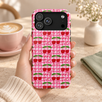 Cherry Gingham MagSafe case, red cherries on hot pink gingham, lifestyle photo in hand with coffee