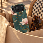 Emerald Magnolia protective phone case, blush magnolias on emerald green, lifestyle photo in a handbag