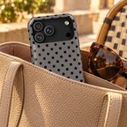 Gray Polka Dot protective phone case, black polka dots on soft gray, lifestyle photo in a handbag