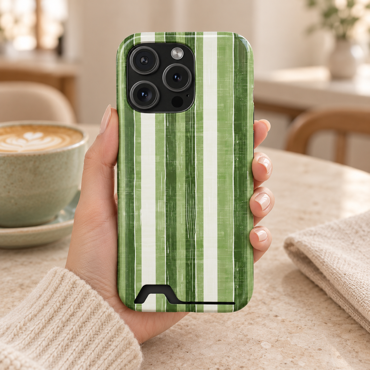 Green Stripe phone case with card holder, painted green and white stripes, lifestyle photo in hand with coffee