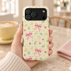 Lemon Bow Gingham protective phone case, pink bows and tiny flowers on lemon gingham, lifestyle photo in hand with coffee