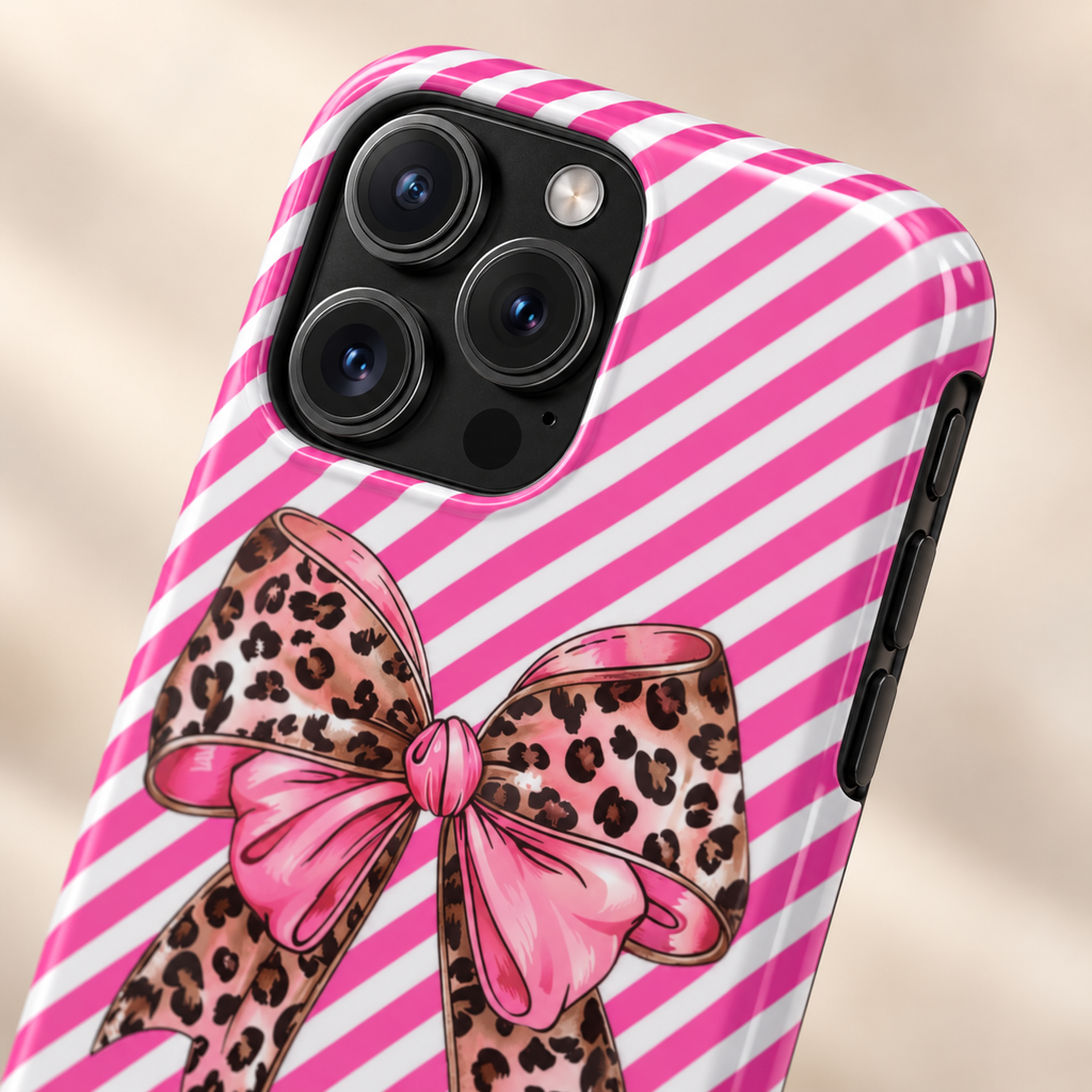 Leopard Bow protective phone case, a leopard print bow on pink diagonal stripes, lifestyle close-up of the camera