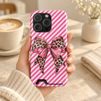 Leopard Bow phone case with card holder, a leopard print bow on pink diagonal stripes, lifestyle photo in hand with coffee