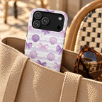 Lilac Seashell MagSafe case, lilac seashells and bows on soft stripes, lifestyle photo in a handbag