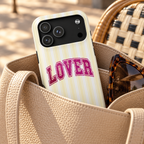 Lover Varsity MagSafe case, pink varsity LOVER lettering on pale yellow stripes, lifestyle photo in a handbag