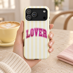 Lover Varsity MagSafe case, pink varsity LOVER lettering on pale yellow stripes, lifestyle photo in hand with coffee