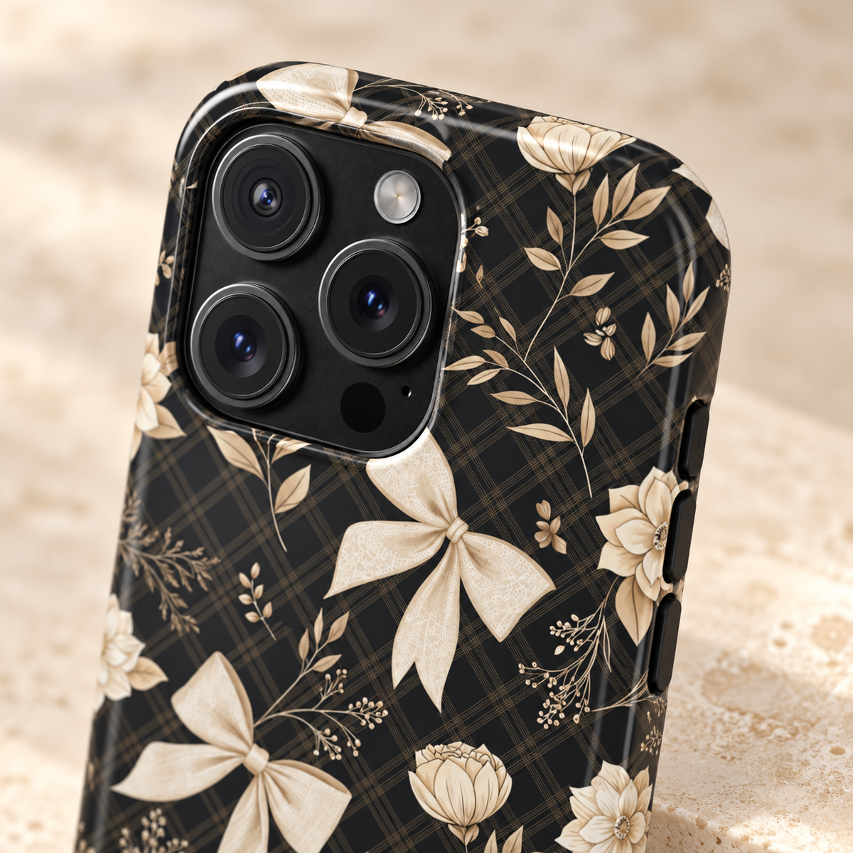 Midnight Bow MagSafe case, cream bows and golden florals on black, lifestyle close-up of the camera