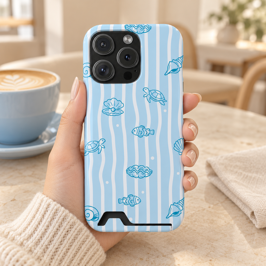 Ocean Doodle Stripe phone case with card holder, seashell and turtle doodles on wavy blue stripes, lifestyle photo in hand with coffee