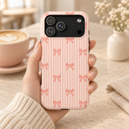 Peach Bow Stripe protective phone case, peach bows on soft peach stripes, lifestyle photo in hand with coffee