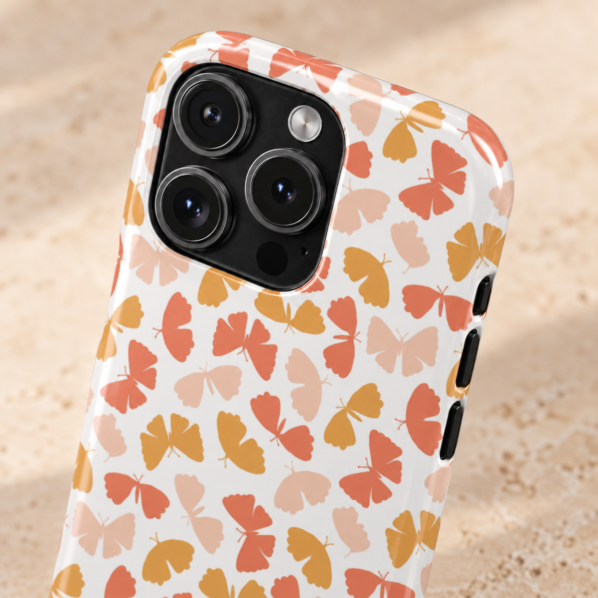Peach Butterfly MagSafe case, little peach, coral and mustard butterflies on white, lifestyle close-up of the camera