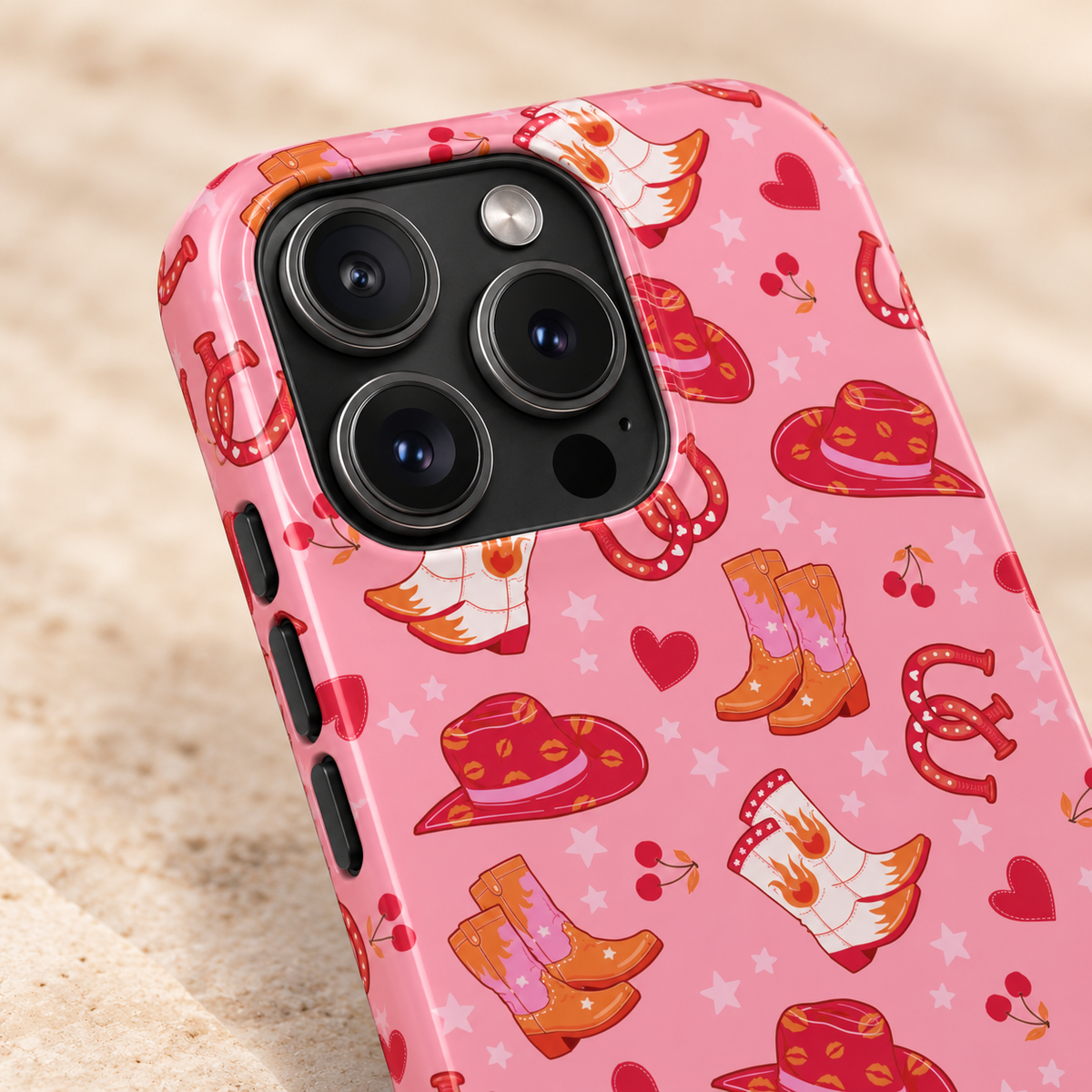 Pink Cowgirl protective phone case, cowgirl hats, boots, horseshoes and hearts on pink, lifestyle close-up of the camera