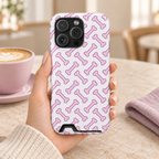 Pink Dog Bone phone case with card holder, pink dog bones on white, lifestyle photo in hand with coffee