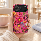 Pink Folk Floral protective phone case, bright folk-style flowers on hot pink, lifestyle photo in hand with coffee