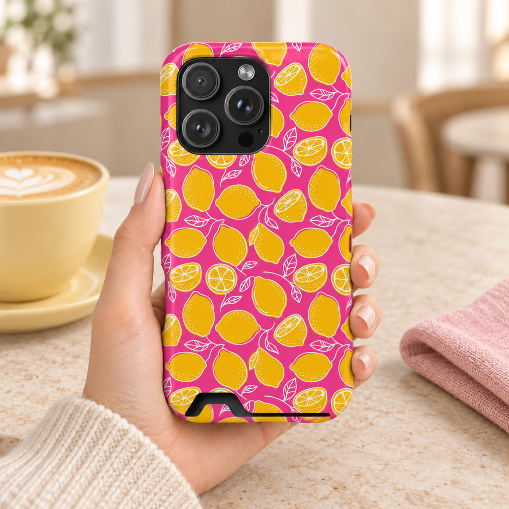 Pink Lemonade phone case with card holder, yellow lemons on hot pink, lifestyle photo in hand with coffee
