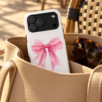 Pink Ribbon Bow MagSafe case, one soft pink ribbon bow on white, lifestyle photo in a handbag