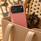 Red Stripe protective phone case, red and white candy stripes, lifestyle photo in a handbag