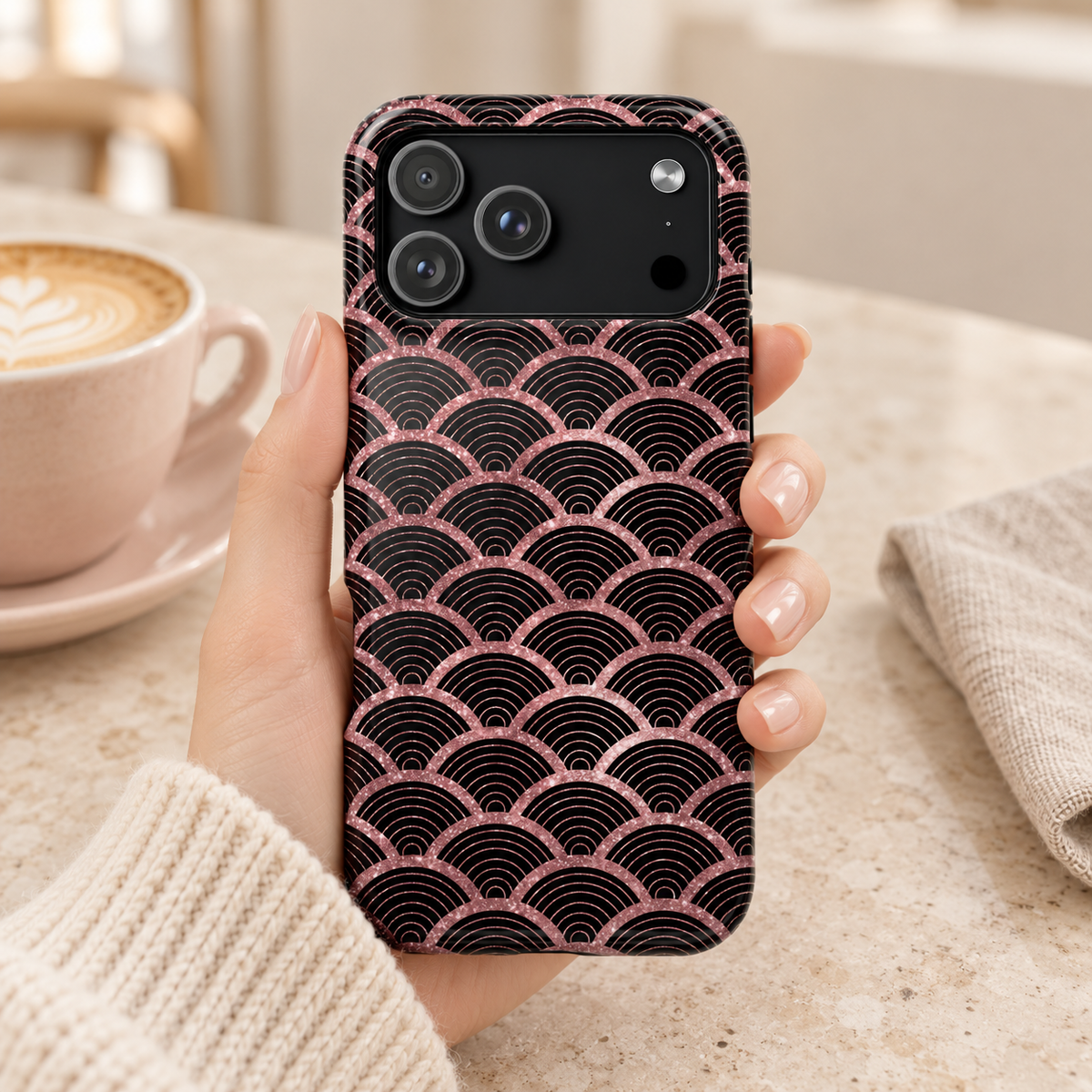Rose Gold Scale protective phone case, rose gold mermaid scales on black, lifestyle photo in hand with coffee
