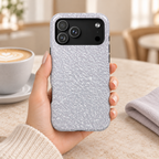 Silver Foil protective phone case, a crinkled silver foil texture, lifestyle photo in hand with coffee